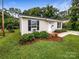 Light beige house exterior with black shutters and a landscaped front yard at 721 3Rd Ave, Gastonia, NC 28054