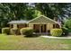 Brick ranch home with covered porch, landscaped yard, and American flag at 7714 Old Waxhaw Monroe Rd, Waxhaw, NC 28173