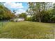 Large backyard with lush green grass and mature trees offering privacy at 115 E Georgia Ave, Bessemer City, NC 28016