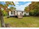Updated white ranch home with a welcoming deck and steps leading to the entrance at 115 E Georgia Ave, Bessemer City, NC 28016