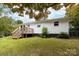Side view of the white ranch home showcasing the deck and backyard access at 115 E Georgia Ave, Bessemer City, NC 28016