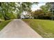 White ranch home nestled on a hillside, accessible by a long driveway at 115 E Georgia Ave, Bessemer City, NC 28016