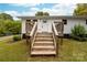 Inviting front exterior with wooden steps leading to the front door and a deck at 115 E Georgia Ave, Bessemer City, NC 28016