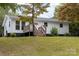 White Ranch house with wooden deck and steps at 115 E Georgia Ave, Bessemer City, NC 28016