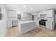 Updated kitchen features white shaker cabinets, quartz countertops, and stainless steel appliances at 115 E Georgia Ave, Bessemer City, NC 28016