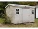 White vinyl storage shed with double doors and two windows at 115 E Georgia Ave, Bessemer City, NC 28016