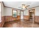 Living room with wood floors, ceiling fan, and wood paneling at 323 20Th St, Kannapolis, NC 28083