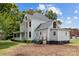 Large two-story house with gray siding, a porch, and a large yard at 101 E Main St, Cleveland, NC 27013