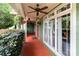 Brick porch with ceiling fan, red door, and lush greenery at 8244 Dumphries Dr, Huntersville, NC 28078