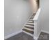 Modern staircase with dark wood steps and white railing at 2642 Roseglen Ln, Indian Land, SC 29707