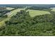 Aerial view of a wooded area adjacent to farmland at 12136 Renee Ford Rd, Stanfield, NC 28163