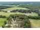 Aerial view of a residential area with houses nestled among trees and open fields at 12136 Renee Ford Rd, Stanfield, NC 28163