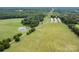 Aerial view of farmland with pond and power lines at 12136 Renee Ford Rd, Stanfield, NC 28163