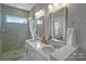 Modern bathroom with a walk-in shower, double vanity, and neutral colors at 12119 Brooklyn Ave, Charlotte, NC 28204
