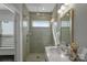 Modern bathroom with a glass shower, white vanity, and neutral tile at 12119 Brooklyn Ave, Charlotte, NC 28204