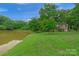 House with a pond and lush green landscape at 15610 Youngblood Rd, Charlotte, NC 28278