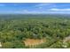 Aerial view showing a home nestled in a lush wooded area with a pond at 15610 Youngblood Rd, Charlotte, NC 28278