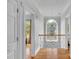 Spacious upper hallway with hardwood floors, an arched window, and elegant light fixture at 15610 Youngblood Rd, Charlotte, NC 28278