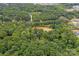 Aerial view of house and pond surrounded by lush green trees at 15610 Youngblood Rd, Charlotte, NC 28278
