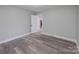 Bright bedroom with wood-look floors and an open doorway to another room at 5625 Highway 601 Hwy, Salisbury, NC 28147