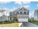 Two-story house with stone and shingle exterior, white garage door, and landscaping at 102 Ballantree Rd # 70, Mooresville, NC 28115