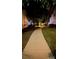 Curving sidewalk at night, lined with lush green grass and trees at 12111 Frogs Leap Ct, Charlotte, NC 28277