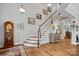 Bright foyer with hardwood floors, staircase, and antique clock at 16015 Vale Ridge Dr # 133, Charlotte, NC 28278