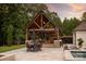 Covered outdoor kitchen with stone counters and pizza oven at 514 Billy Howey Rd, Waxhaw, NC 28173