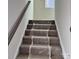 Staircase with gray carpeting and wooden railing at 1483 Honey Trl, Monroe, NC 28112