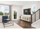 Spacious living room with a large TV, balcony access, and hardwood floors at 8009 Elevate Ct, Charlotte, NC 28205