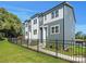 Modern 3-unit townhome building with gray and white siding, black fence, and landscaping at 8009 Elevate Ct, Charlotte, NC 28205