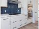 Modern kitchen with white cabinets, blue tile backsplash, and stainless steel appliances at 8009 Elevate Ct, Charlotte, NC 28205