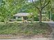 House nestled amongst mature trees, showcasing curb appeal at 8 Blackberry Ln, Lake Wylie, SC 29710