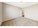 Bright bedroom with neutral walls and carpet, featuring a door to hallway at 7025 Stella Pl, Stanley, NC 28164