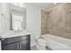 Modern bathroom with dark vanity, white bathtub, and beige tile at 1432 Hamilton St # 14, Charlotte, NC 28206