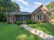 Brick house with screened porch, landscaped yard, and walkway at 10227 Mount Holly Rd, Charlotte, NC 28214
