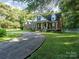 Brick and white home with a covered porch and landscaping at 10227 Mount Holly Rd, Charlotte, NC 28214