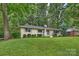 Brick ranch house with a lush green lawn in a wooded area at 5328 Seacroft Rd, Charlotte, NC 28210