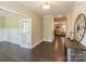 Spacious entry with dark hardwood floors, open view to living room, and decorative clock at 6997 Cobblefield Ln, Denver, NC 28037