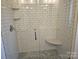 Walk-in shower with subway tile surround, built-in corner seat, and glass door at 1886 Hollybrook Ln, Lancaster, SC 29720