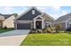 House exterior featuring stone and siding accents, a two-car garage, and a manicured lawn at 1346 Millview Ln, Matthews, NC 28104
