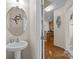 Convenient powder room with pedestal sink and a view into the kitchen at 9341 Lenox Pointe Dr, Charlotte, NC 28273