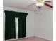 Empty bedroom with pink carpet, ceiling fan, and green curtains at 452 Mocksville Hwy, Statesville, NC 28625