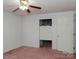 Bedroom with pink carpet, ceiling fan, and access to bathroom at 452 Mocksville Hwy, Statesville, NC 28625