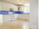 Galley kitchen with white cabinets, blue countertops, and tiled floor at 452 Mocksville Hwy, Statesville, NC 28625