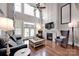 Light-filled living room featuring hardwood floors and a cozy fireplace at 19577 Meta Rd, Cornelius, NC 28031