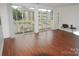 Bright living room with laminate floors and sliding glass doors leading to a balcony at 1600 H Arlyn Cir, Charlotte, NC 28213