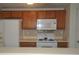 Kitchen boasts wood cabinets, white appliances, and tile backsplash at 1600 H Arlyn Cir, Charlotte, NC 28213
