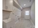 Laundry room with sink, built-in shelving, and tile flooring at 4020 Landsford Rd, Marshville, NC 28103