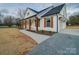 White farmhouse with brown accents, covered porch, and gravel driveway at 4020 Landsford Rd, Marshville, NC 28103